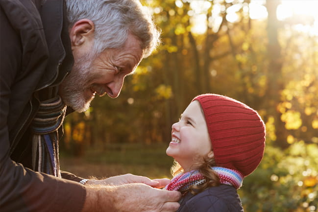 A man prepares a little girl for cold weather.
