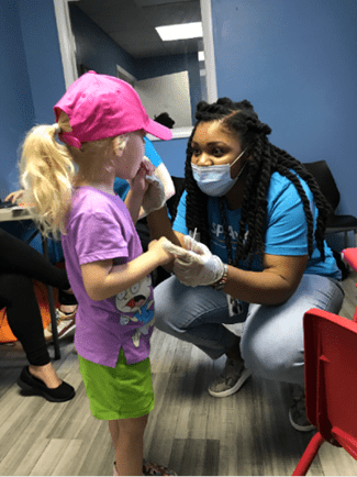 A SPARK team member talks to a pediatric patient.