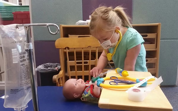 Abby plays doctor on a doll