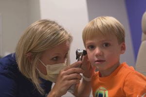 A nurse examines a child's inner ear.