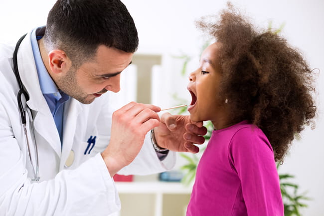 Child getting her throat checked by doctor
