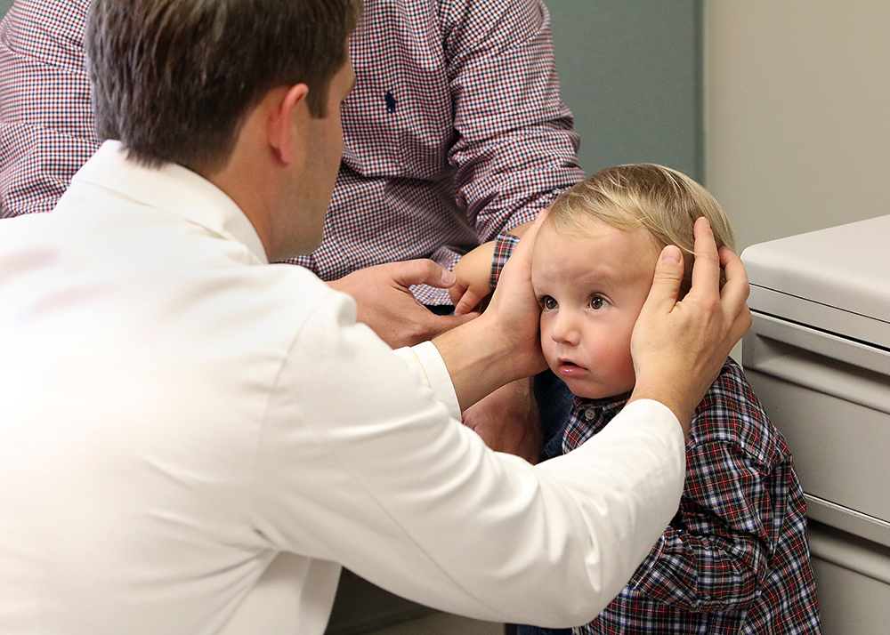 A doctor feels toddler Rhett Bausmith's head