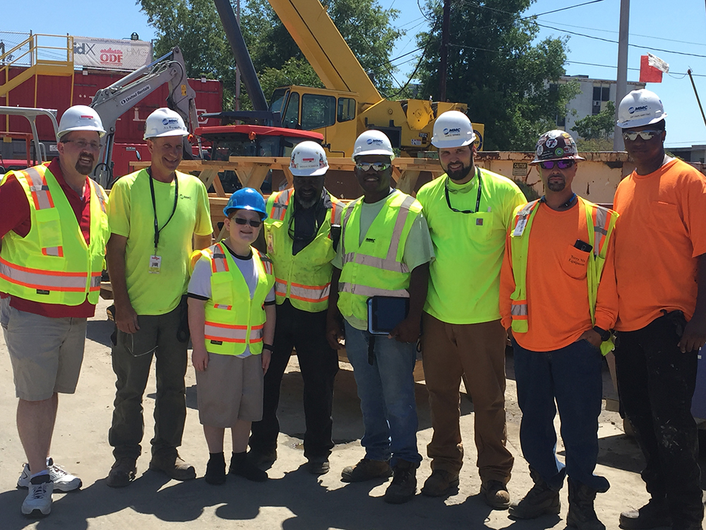 group photo of Riley Klim with workers