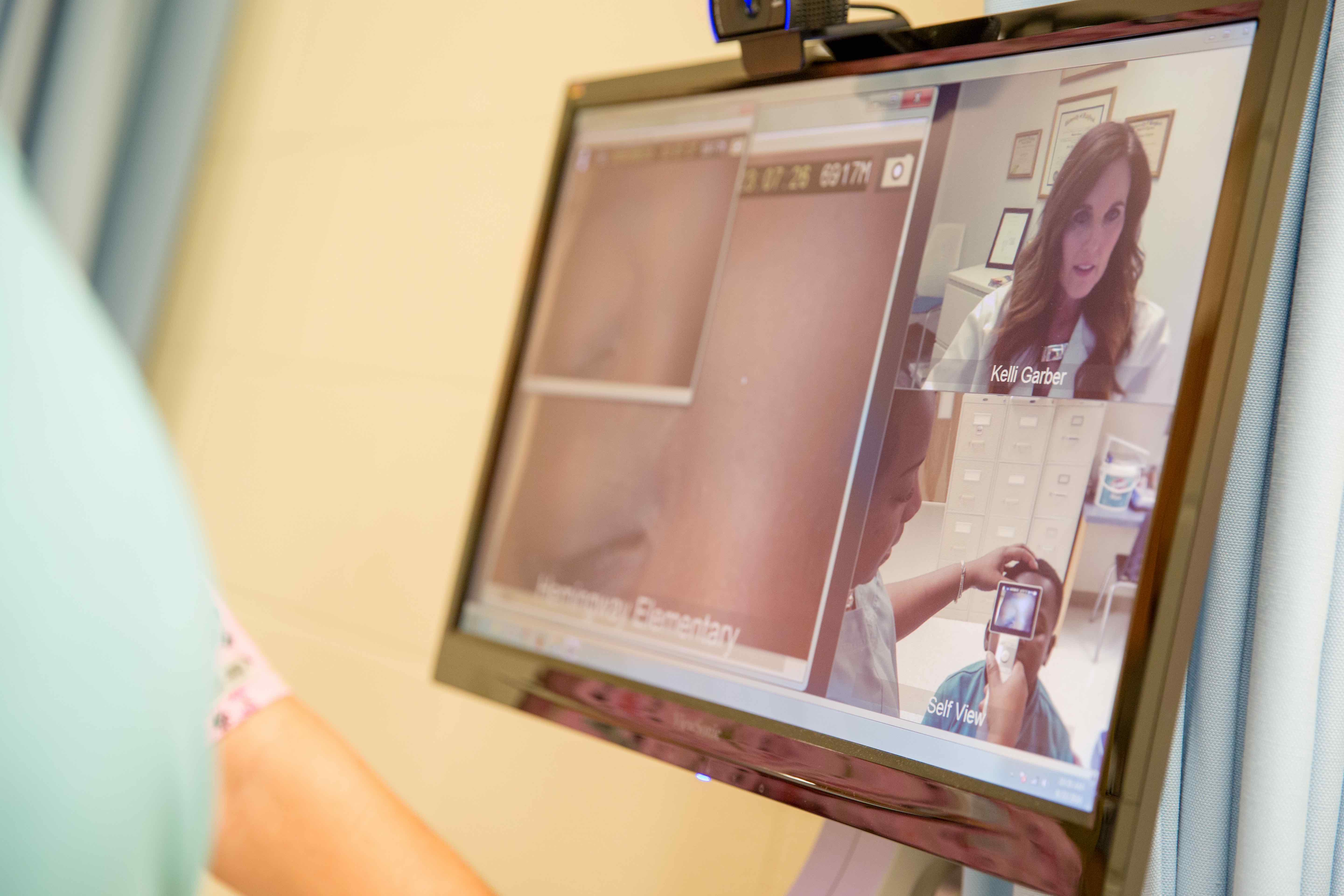 Close-up of Telehealth monitor showing Kelli Garber, MSN, APRN, lead nurse practitioner & clinical integration specialist at the Medical University of South Carolina Center for Telehealth, and a student