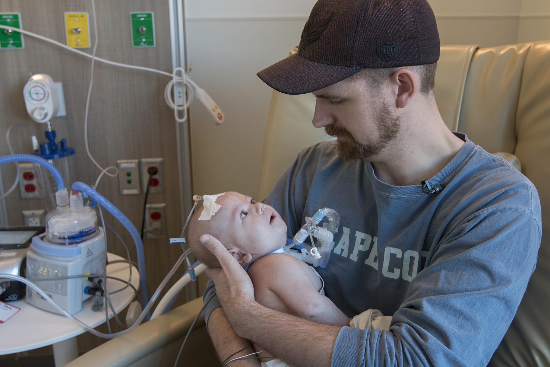 man holds his infant son in hospital