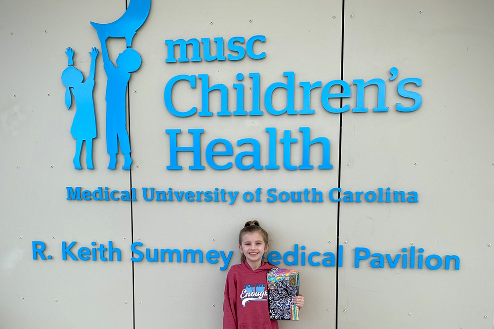 girl stands in front of the sign on the Summey Medical Pavilion