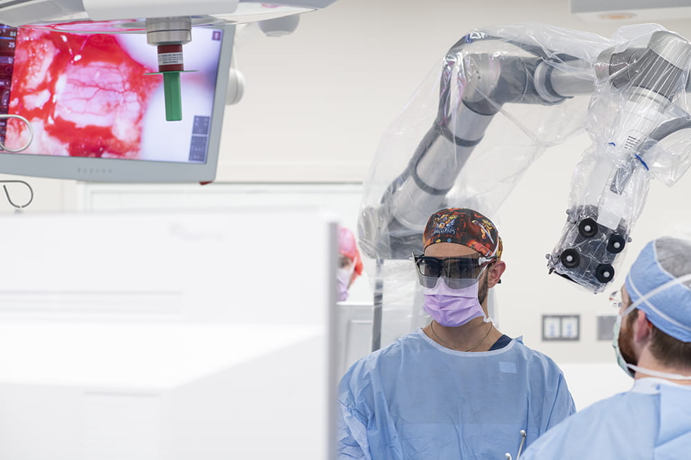 Dr. Eskandari looks at a screen that shows an enlarged 3D image of the area where he is operating