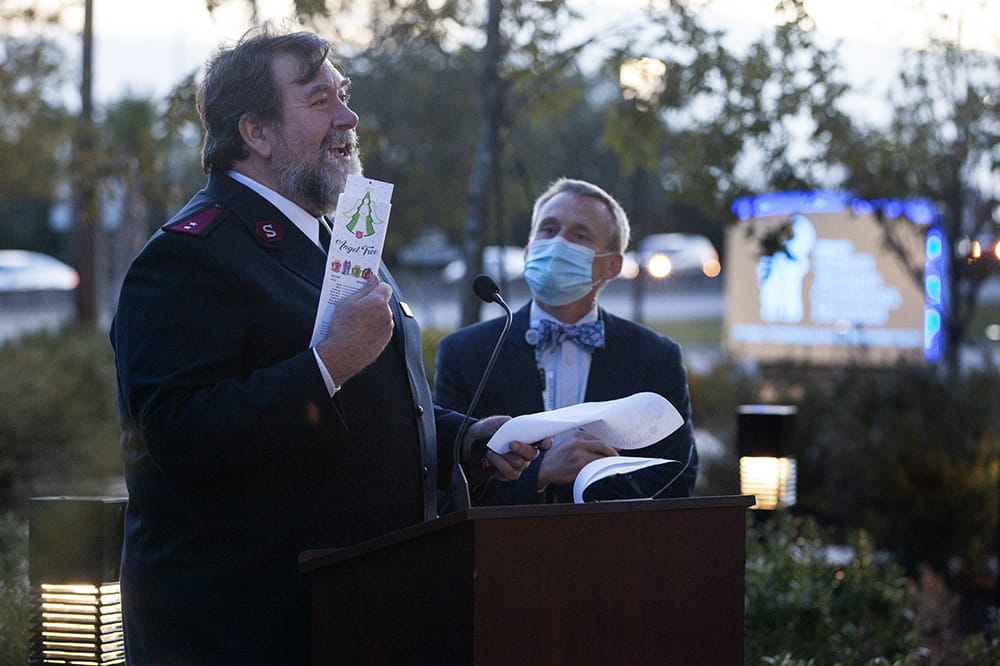 Salvation Army Captain Mike Michels holds an Angel Tree tag while Dr. David Zaas watches.