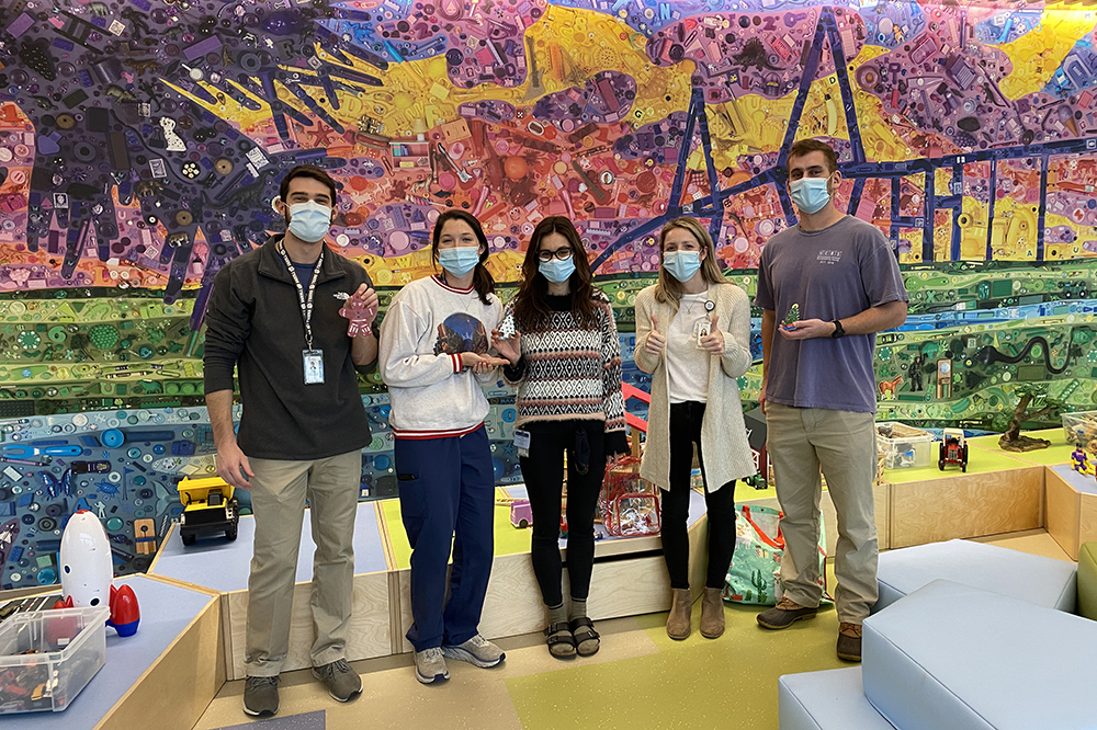 five medical students pose in the colorful play atrium in the children's hospital