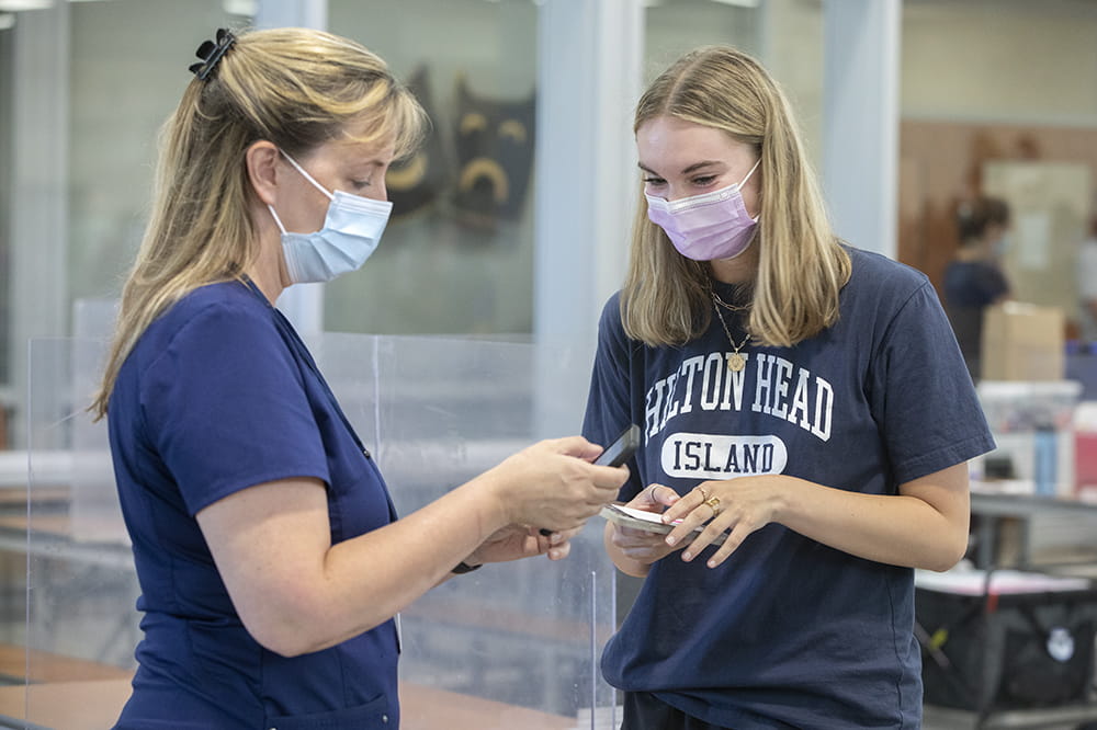 Nurse Danielle Lupton talks with student Emilee Haas.