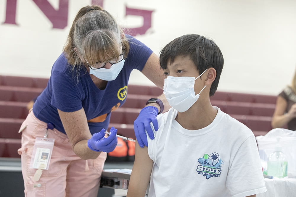 Thomas Nguyen, 13, gets COVID vaccine from nurse Kim Edwards of the Charleston County School District.
