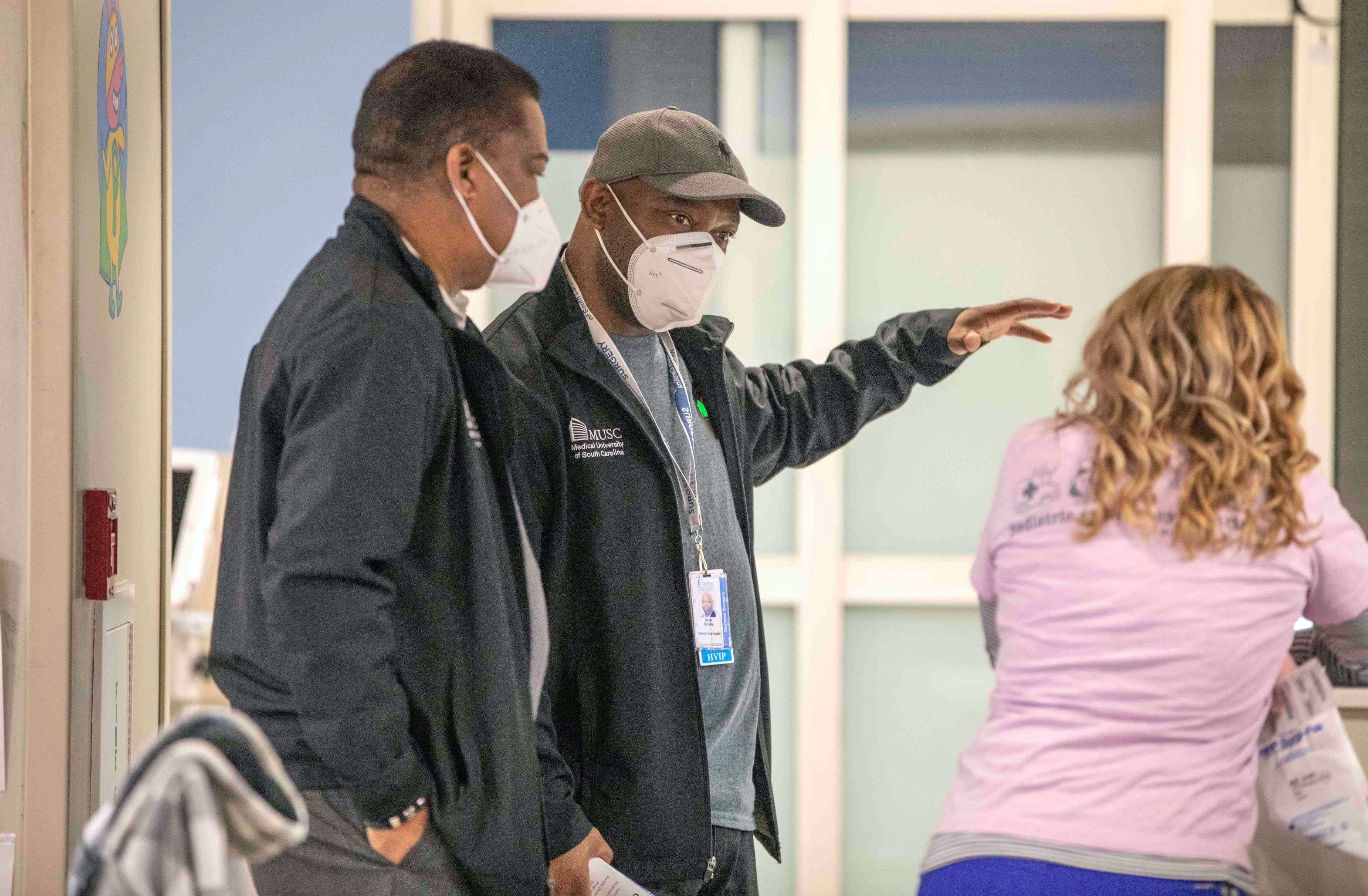 Smalls and his program director talk with a nurse in the hospital