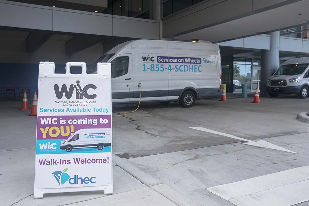 WIC sign and WIC van in parking lot.