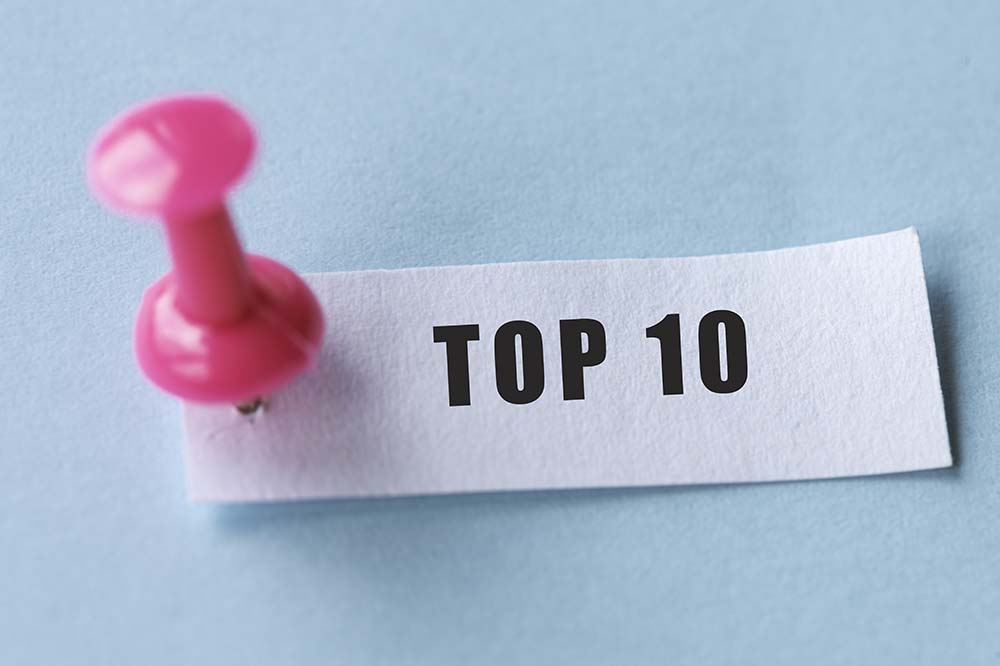 Pink pin on slip of paper that says top 10. It's on a blue background.