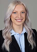 Headshot of woman with long blonde hair. She's smiling and waring a blue jacket and shirt.
