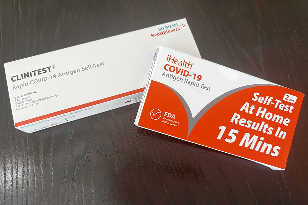 Two boxes. One says Clintest. The other says self-test at home. results in 15 minutes. Both are COVID test kits.