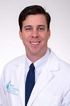 Headshot of man in white doctor's coat