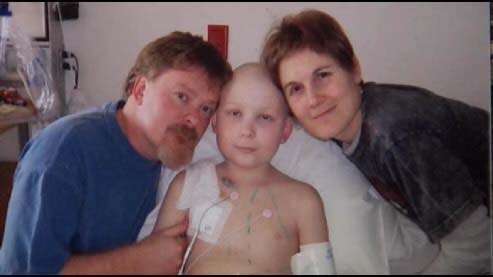 Child in a hospital is surrounded by a man and a woman