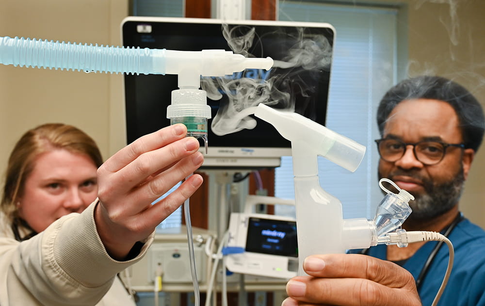 Two people holding a respiratory device 