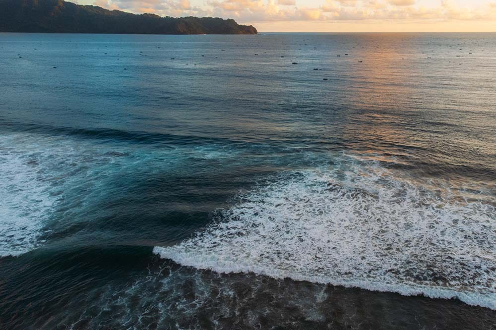 Blue water against a cloudy sky. The water is swirling.